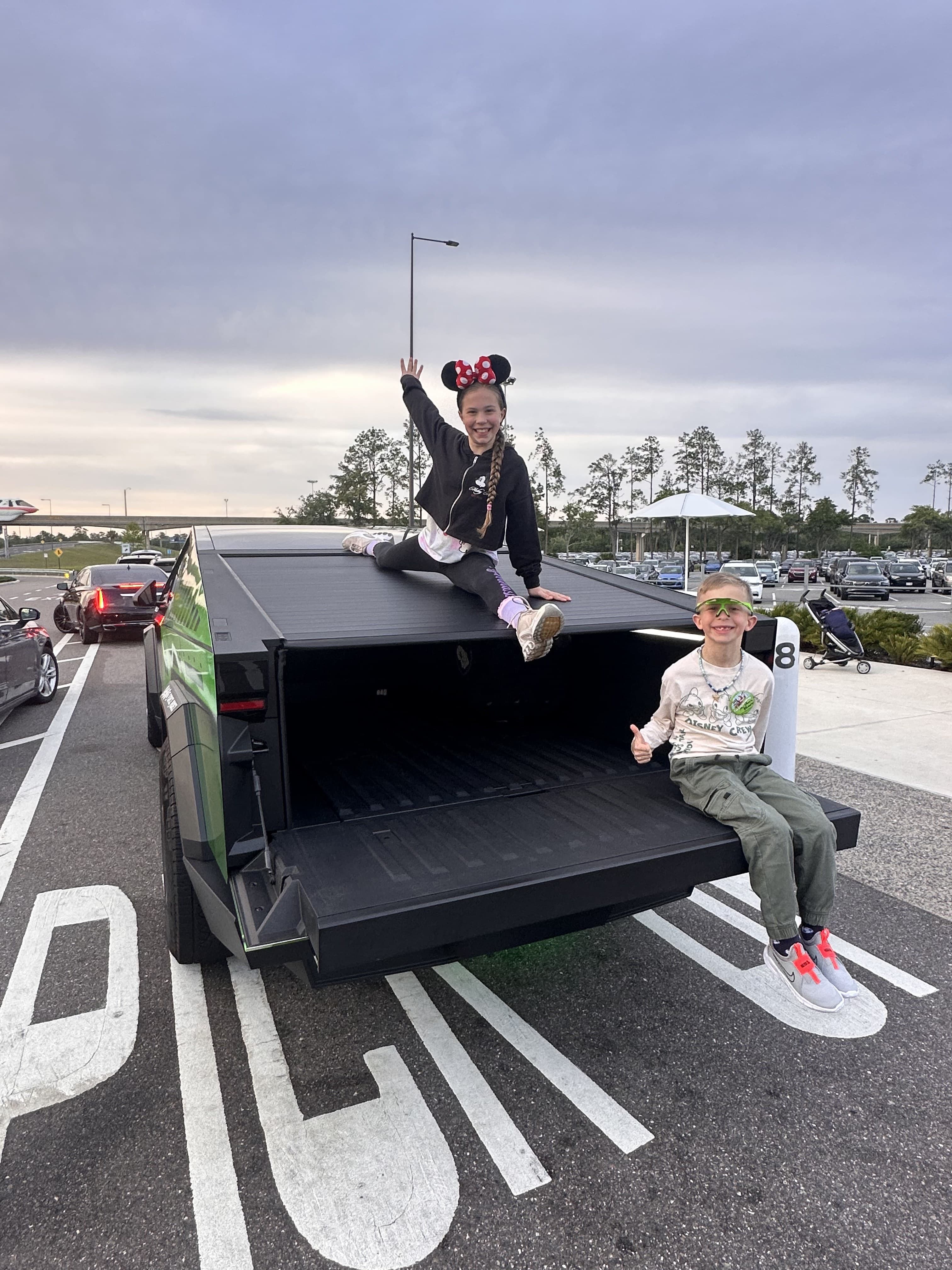 Kids in the G-Force Ridez Cybertruck bed after a theme park day