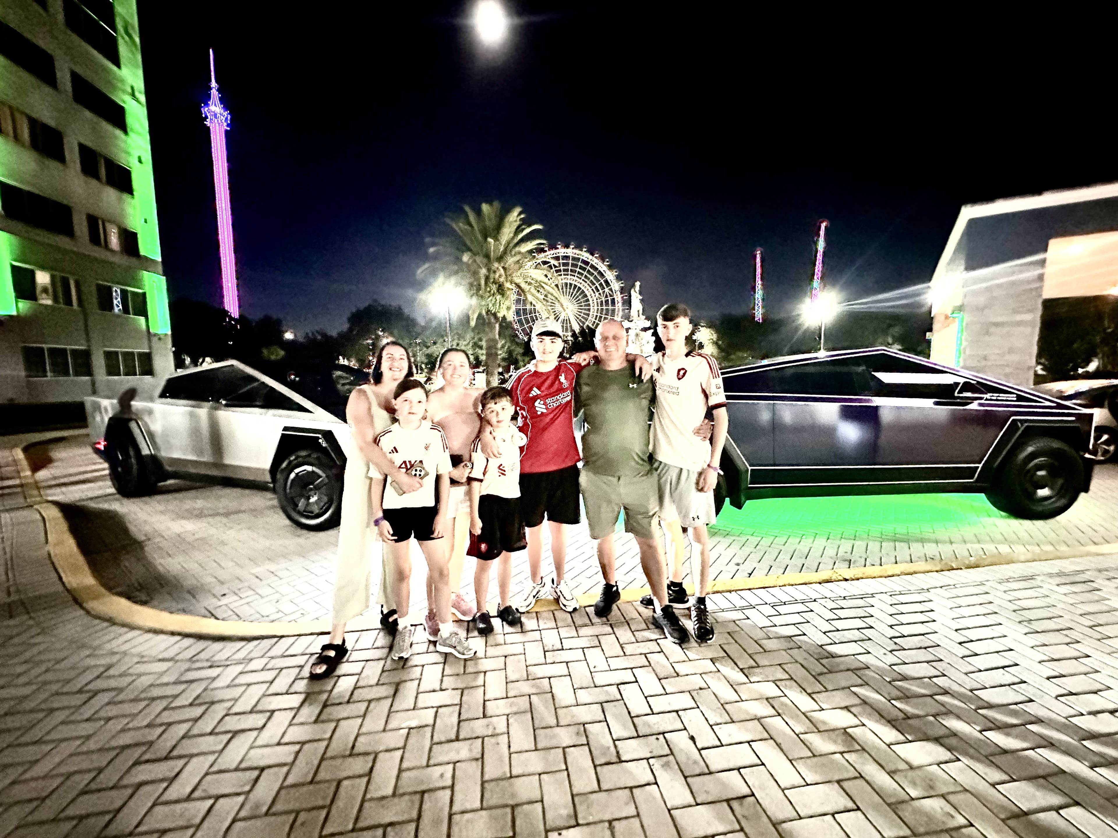 Family posing with two G-Force Ridez Cybertrucks near ICON Park Orlando